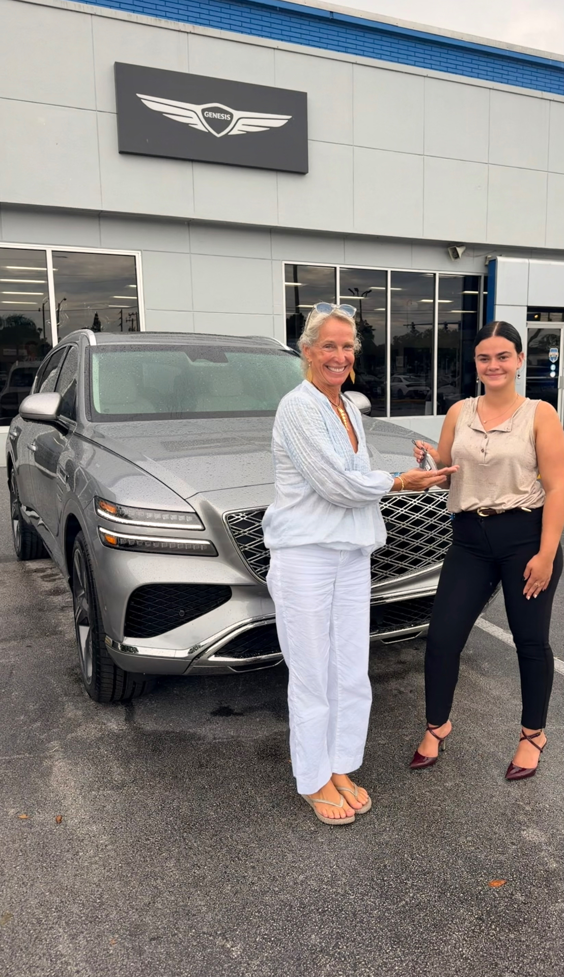 Alexis handing keys to a happy Genesis GV80 customer