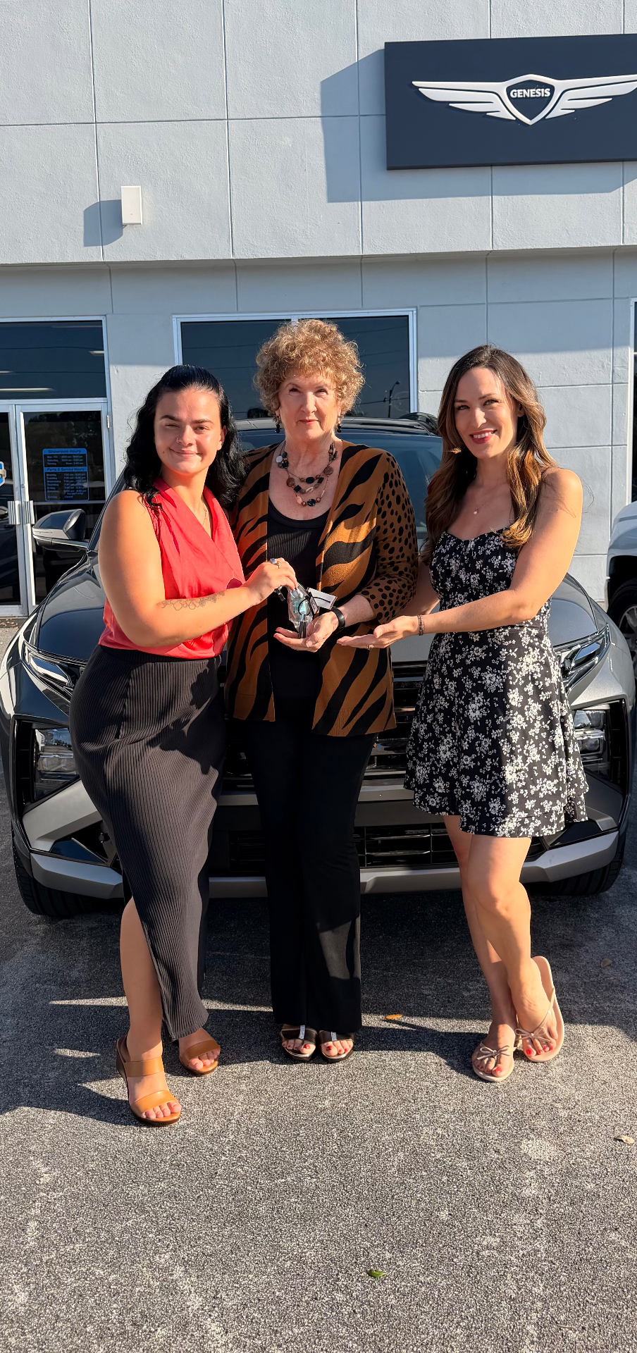 Alexis with two longtime customers celebrating at the dealership